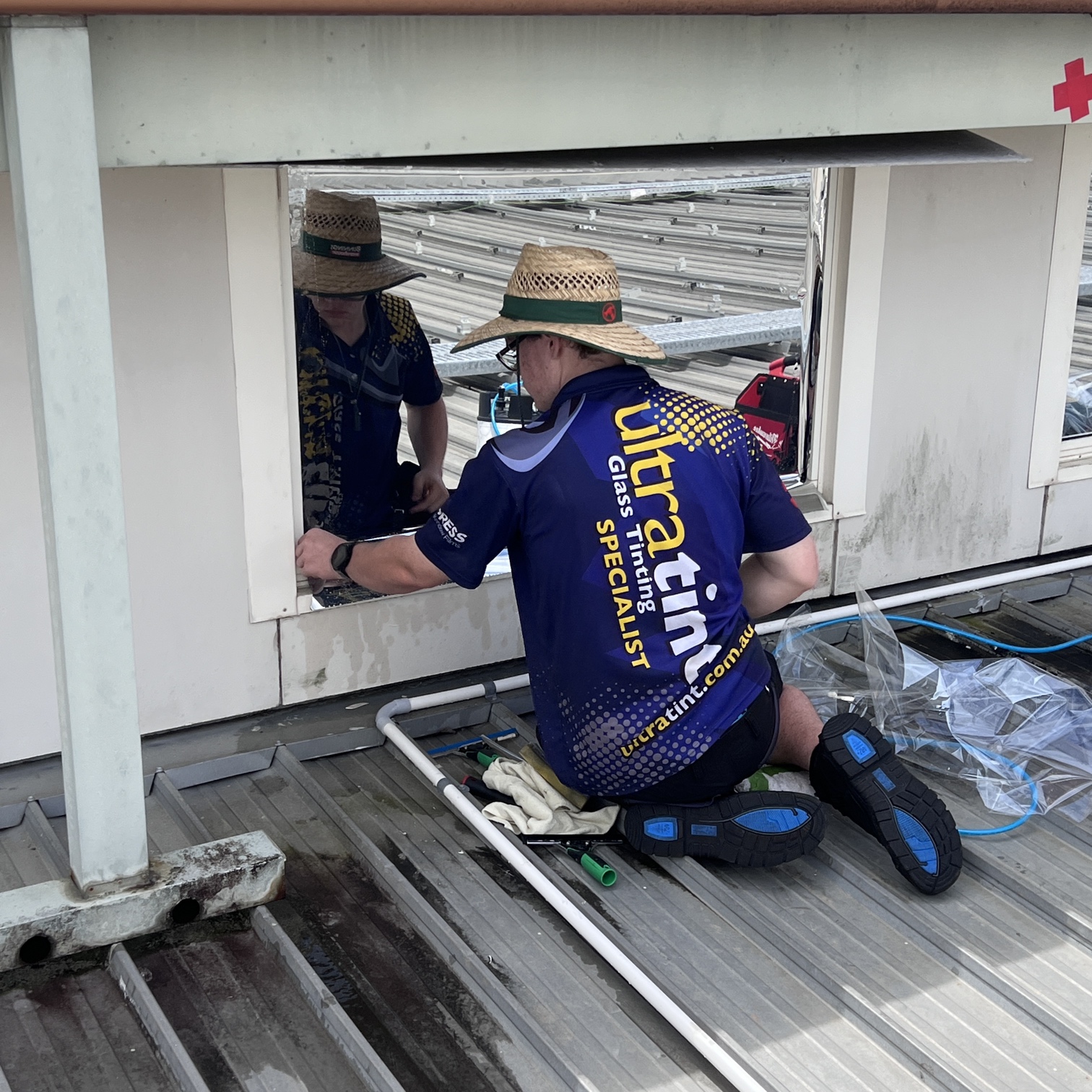 Ultra Tint installer applying external window film to rooftop glazing.