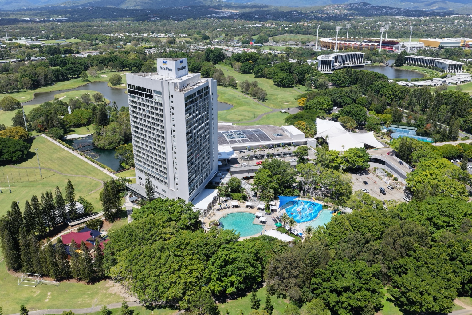 Aerial view of RACV Royal Pines Resort tower overlooking the pool and landscaped resort areas.