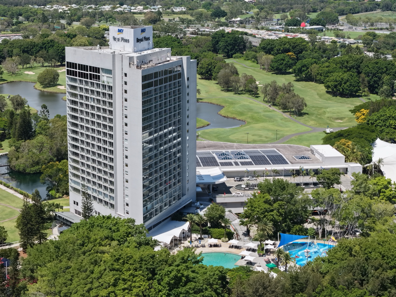 Side aerial view of RACV Royal Pines Resort beside the resort pool and grounds.