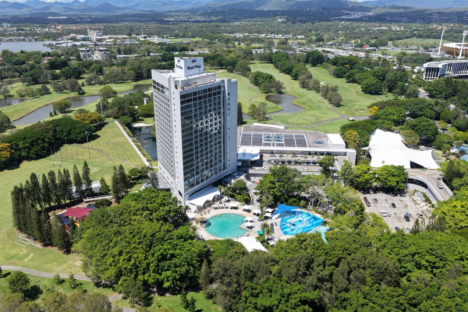 Aerial view of RACV Royal Pines Resort showing the high-rise tower and surrounding resort grounds.